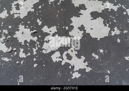 gray background of an old wall with peeling paint. Stock Photo