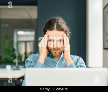 Focused male company employee trying to concentrate Stock Photo