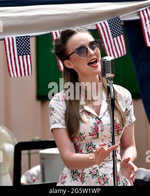 Vintage female singer performing in 1940s dress during the annual War on the Line event, Aresford, Hampshire, UK. 13 June 2021. Stock Photo