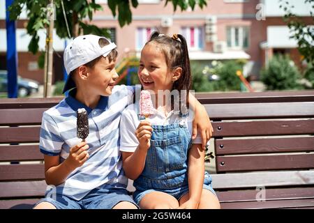 beautiful little boy and girl eating ice cream in summer Stock Photo