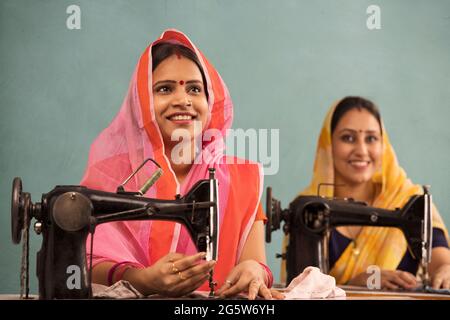 Two rural women working together on sewing machine. Stock Photo