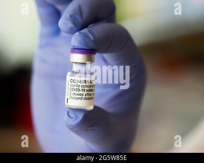 Kiev, Ukraine, June 30, 2021. In this photo illustration, a Nurse is holding a Pfizer / BioNTech Comirnaty COVID-19 vaccine vial. Stock Photo
