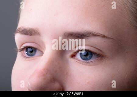 Close up of blue eyes of caucasian businesswoman isolated on grey background Stock Photo