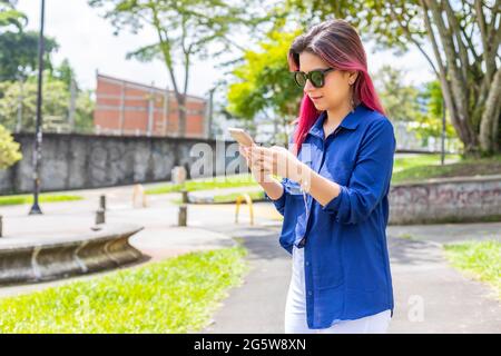 stylish young woman texting with smart phone in outdoors Stock Photo