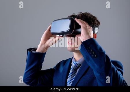 Caucasian businessman wearing vr headset, isolated on grey background Stock Photo