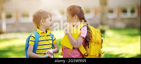 Two cute children standing in the schoolyard park Stock Photo