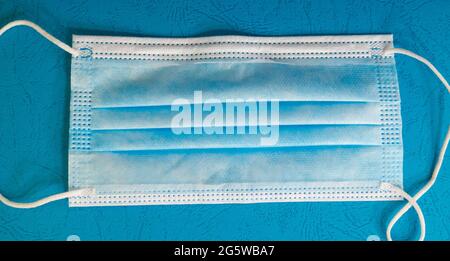 Blue medical mask on a blue background. Stock Photo