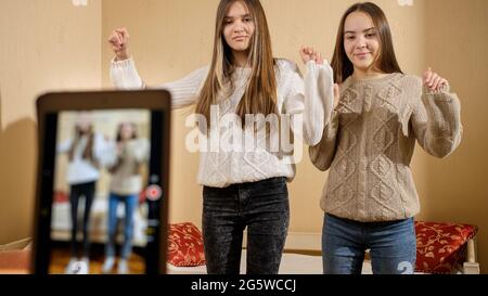 Smartphone recording video of two teenage bloggers dancing online for social media. Modern communication, social media and gadgets Stock Photo