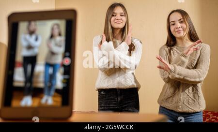 Two young teenage bloggers recording video of their dance in internet. Modern communication, social media and gadgets Stock Photo