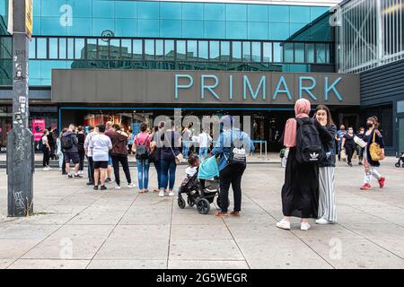 People wearing face masks queue outside Primark Clothing store during Corona Pandemic, Alexanderplatz,Mitte,Berlin Stock Photo