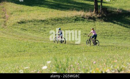 Two girls on mtb bikes. Mother and daughter riding on a trail. Stock Photo