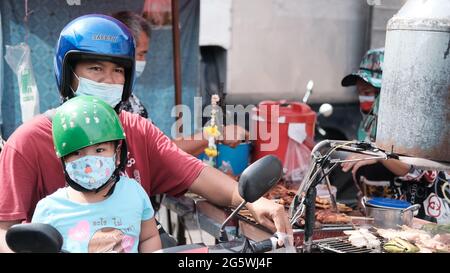Father and Daughter on a Motorbike Klong Toey Market Wholesale Wet Market Bangkok Thailand largest food distribution center in Southeast Asia Stock Photo