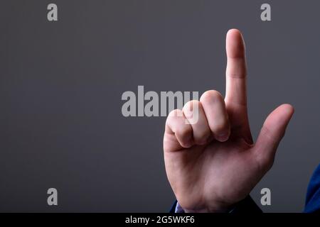 Midsection of caucasian businessman touching virtual interface, isolated on grey background Stock Photo