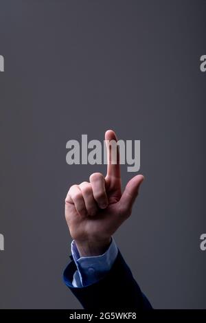 Midsection of caucasian businessman touching virtual interface, isolated on grey background Stock Photo