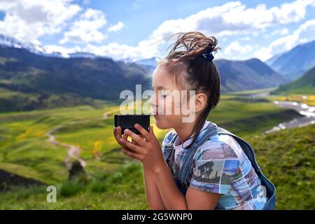 funny beautiful girl holds a mug and drinks tea in the mountains Stock Photo