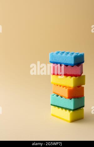 Stack of multicolored dishwashing sponges on neutral beige background, kitchen household and cleaning concept Stock Photo