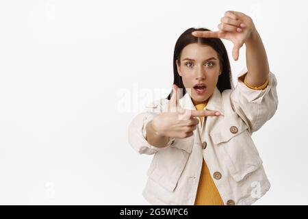 Image of creative and passionate photographer getting inspired, looking through hand frames, woman taking photo, showing her vision, picturing smth Stock Photo