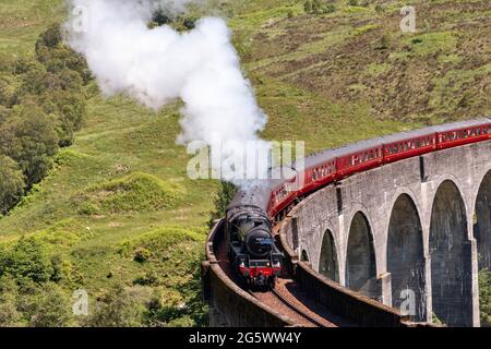 JACOBITE STEAM TRAIN GLENFINNAN VIADUCT SCOTLAND TRAIN 45212 AND PLENTY OF SMOKE IN EARLY SUMMER SUNSHINE Stock Photo