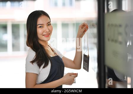 Happy business owner turning open sign and ready to service. Stock Photo