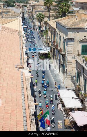 Noto, Syracuse, Sicily, Italy. View along Corso Vittorio Emanuele from rooftop terrace of the Church of San Carlo al Corso, scooter rally in progress. Stock Photo
