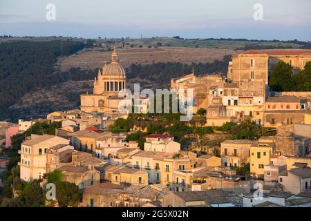 Ragusa, Sicily, Italy. View over the scenic rooftops of Ragusa Ibla, sunset, towering dome of the Cathedral of San Giorgio prominent.