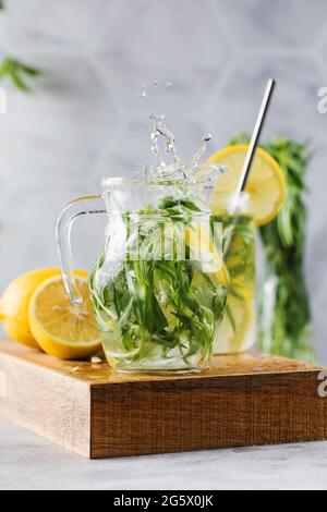Refreshing homemade lemonade with tarragon and lemon in a jug. Summer drinks. Stock Photo
