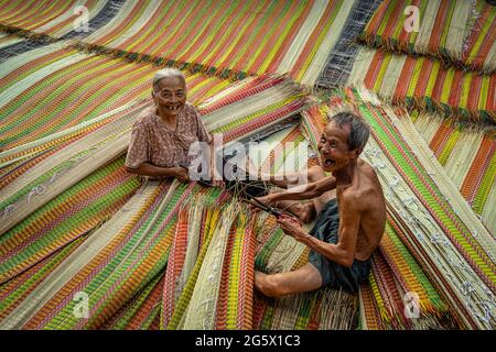 Top view of old Vietnamese lover craftsman making the traditional vietnam mats with happiness action in the old traditional village at dinh yen, dong Stock Photo