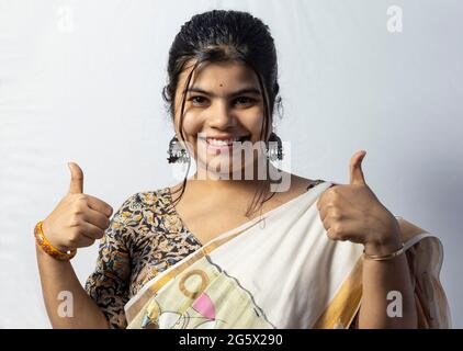 Isolated on white background an Indian female shows double thumbs up with smiling face on white background Stock Photo