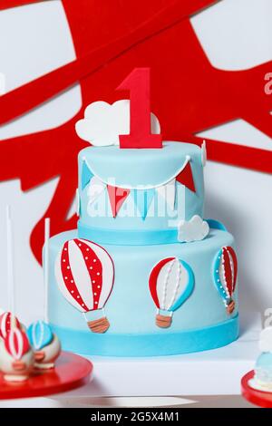 Candy bar on boy's birthday party with a lot of different candies, popcorn, beverages and big cake. Decorated in blue,red and white colors, balloons o Stock Photo
