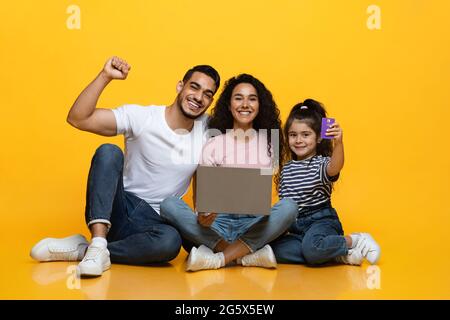 Happy Excited Arabic Family With Laptop And Credit Card Making Online Shopping Stock Photo