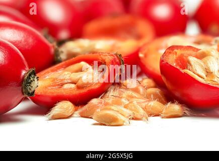 Rosehips Rosa Canina fruits ,cut in half seeds visible macro closeup detail, isolated on white background Stock Photo