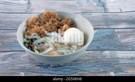 "Laksa" is a spicy noodle soup popular in the Peranakan cuisine. Selective focus of a bowl of "laksa" known in malay. Stock Photo