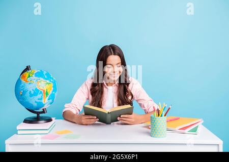 Photo of young pretty charming happy positive girl enjoying reading book homework isolated on blue color background Stock Photo