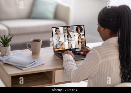 Black woman having online conference with colleagues while working at home office Stock Photo