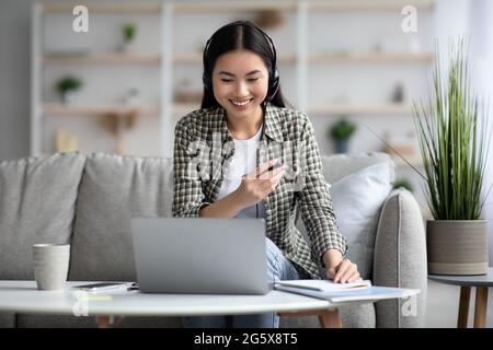 Pretty asian woman attending video conference with co-workers Stock Photo