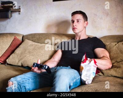 Attractive guy playing videogames with joystick in hand Stock Photo