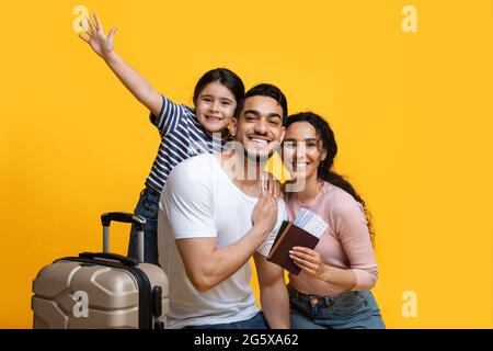 Family Trip Concept. Excited Middle Eastern Parents Travelling With Their Little Daughter Stock Photo