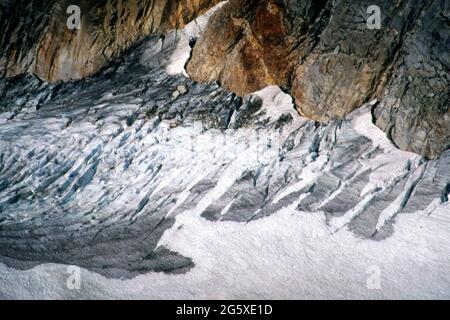 Glacier slides down a mountain on a very cloudy and rainy day in