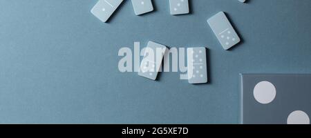 Light Blue wood domino pieces on light blue background. Leisure games concept. Stock Photo