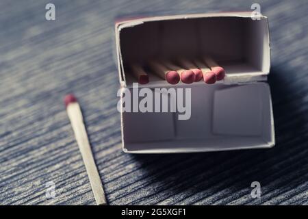 High angle view of matches in a matchbox lying on a wooden table Stock Photo