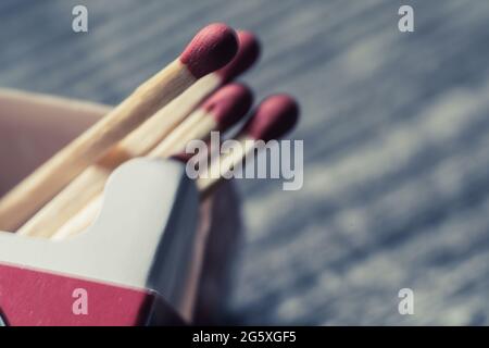 High angle view of matches in a matchbox lying on a wooden table Stock Photo