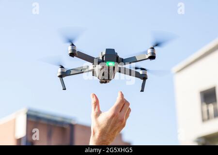 black drone lands in the hands of technician Stock Photo