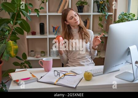 Young pretty woman enjoying snack breaks at home Stock Photo