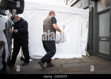 Southgate Street, Gloucester, UK. 19th May 2021.  Investigation police officers enter the Clean Plate cafe in the centre of Gloucester with drilling a Stock Photo