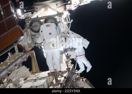 NASA astronaut Shane Kimbrough and ESA astronaut Thomas Pesquet, right, work on the installation of the second roll out solar array on the International Space Station June 25, 2021 in Earth Orbit. Stock Photo