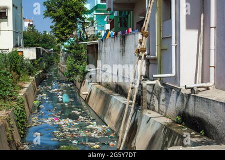 Stream beside building using as dumping site littered with garbage, waste and rubbish, Puducherry (Pondicherry), Tamil Nadu, India Stock Photo