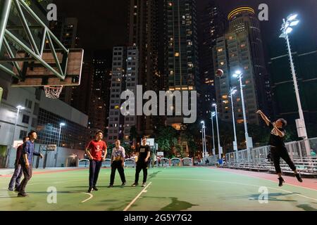 Basketball being played on a city centre court at night in Hong Kong Stock Photo