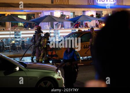Firefighters cutting into the bonnet of a taxi that caught fire in Miami Stock Photo