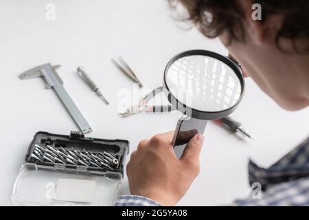 master with tools repair the broken smartphone in the workshop Stock Photo