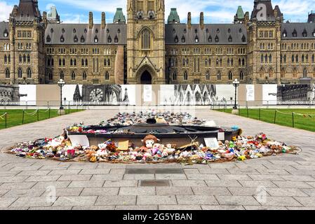 Ottawa, Canada - June 30, 2021: The many shoes and toys left near the Centennial Flame on Parliament Hill in memory of the children whose remains were found near former Residential Schools. Stock Photo